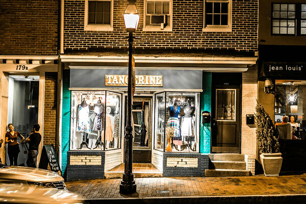 Main Street Picture of a downtown main street with shops, street lamp, and passing cars.